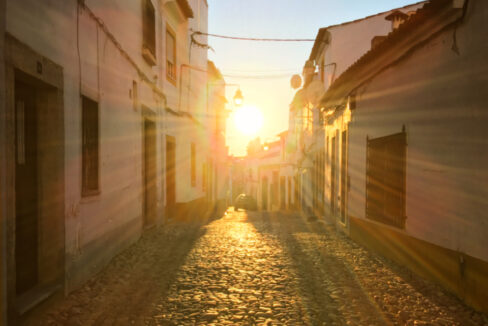 Calle del casco antiguo de una ciudad al atardecer