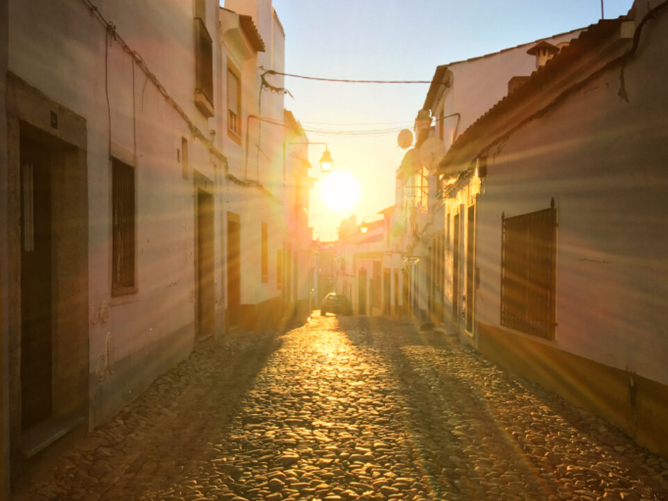 Calle del casco antiguo de una ciudad al atardecer