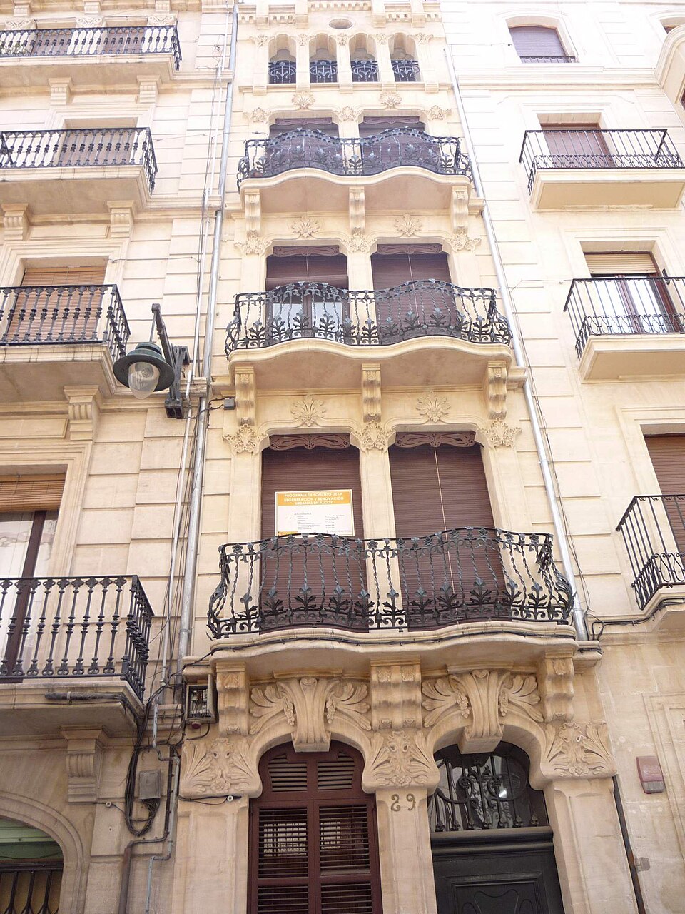 Fachada modernista de un edificio de viviendas con balcones de forja en la calle Sant Nicolau de Alcoy
