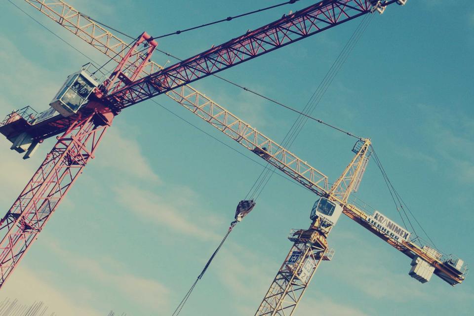 Grúas de construcción levantando un edificio de viviendas protegidas